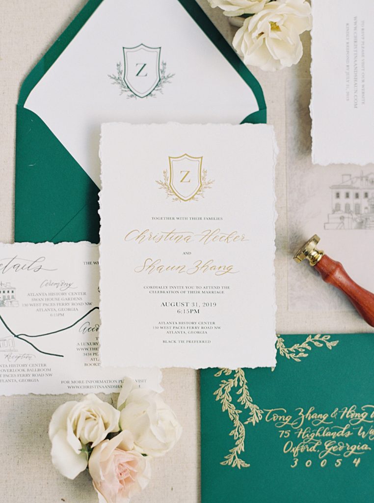 wedding invitation suite wedding details | styled flay lay | gold and green | custom wedding crest