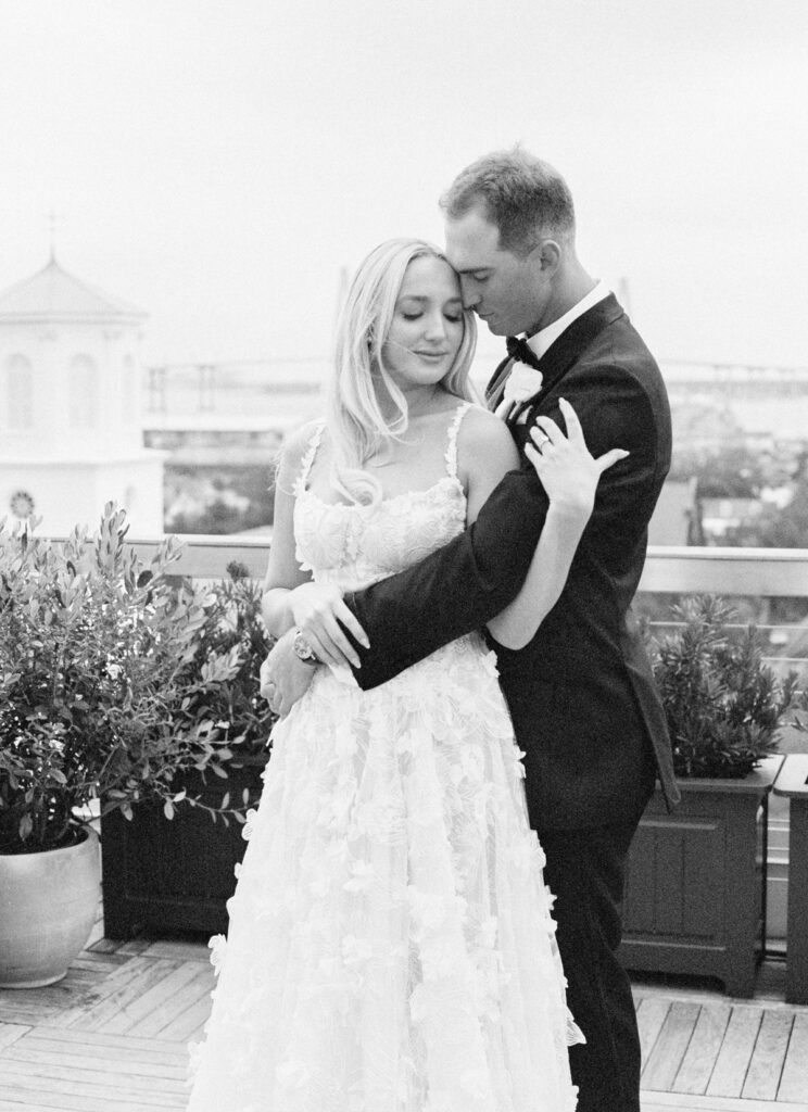 Bride and groom on The Dewberry rooftop overlooking Charleston