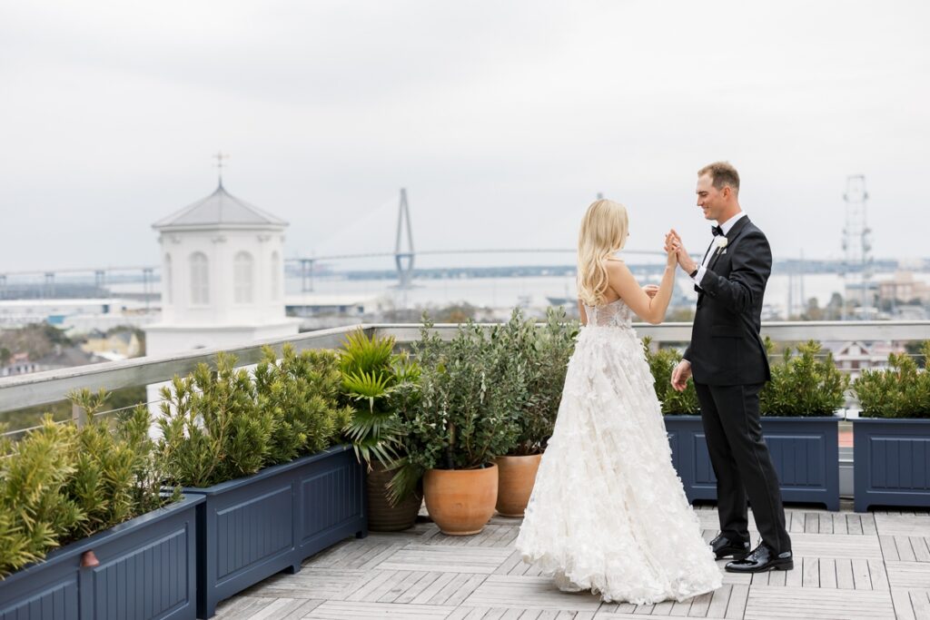 Bride and groom on The Dewberry rooftop overlooking Charleston