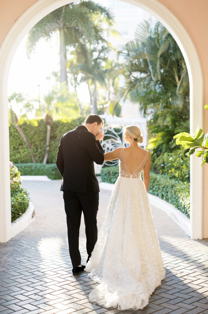 Bride and groom walking through palm trees at The Colony Hotel